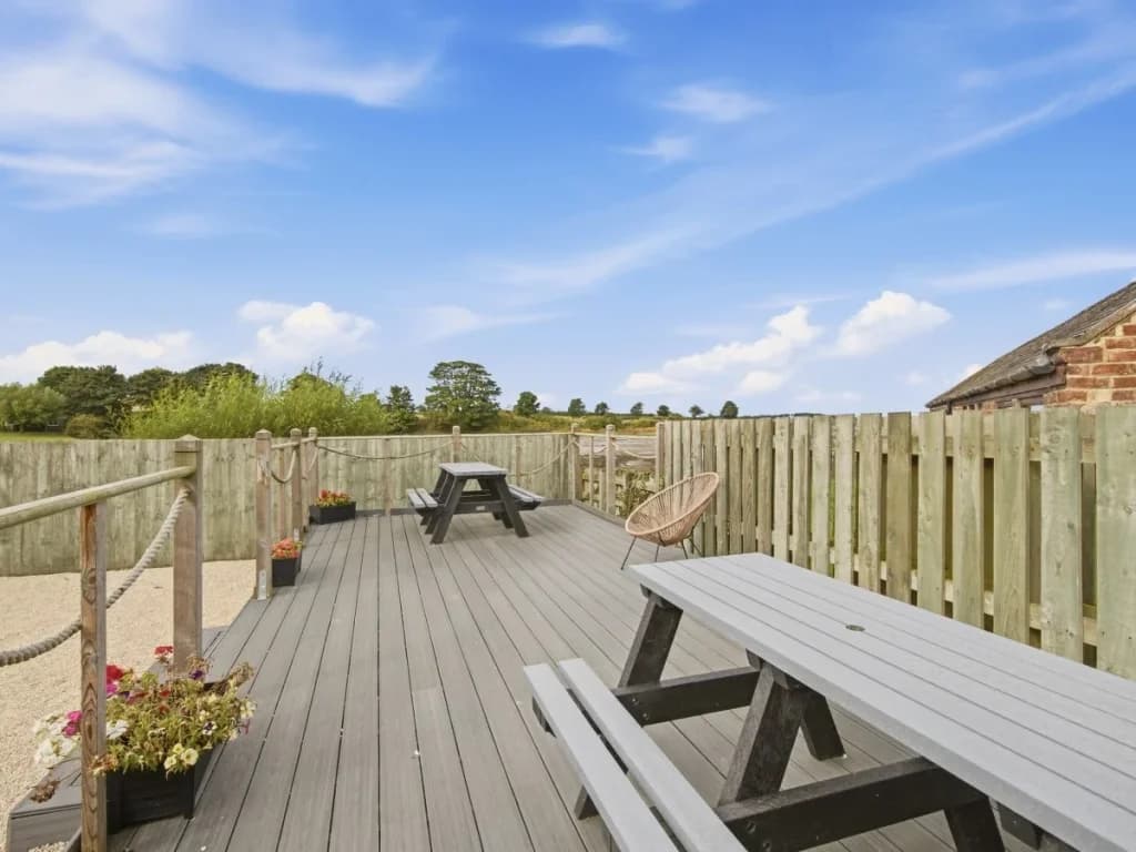 Enclosed decked area with picnic tables and open countryside views