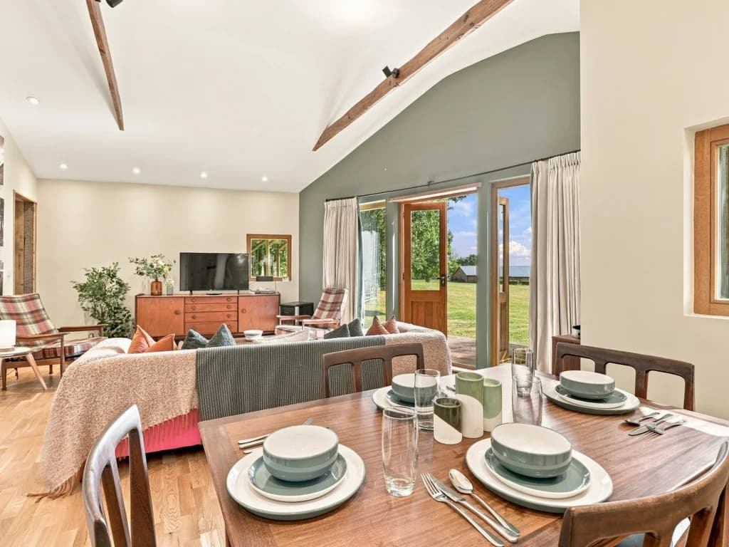 Open living and dining area with doors overlooking the countryside