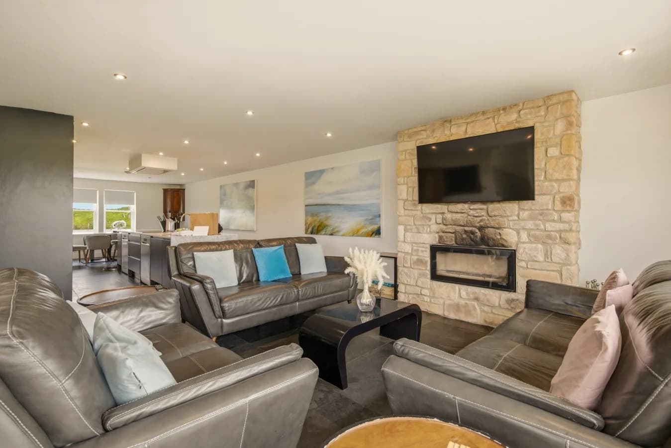 Open-plan lounge with stone fireplace and leather seating