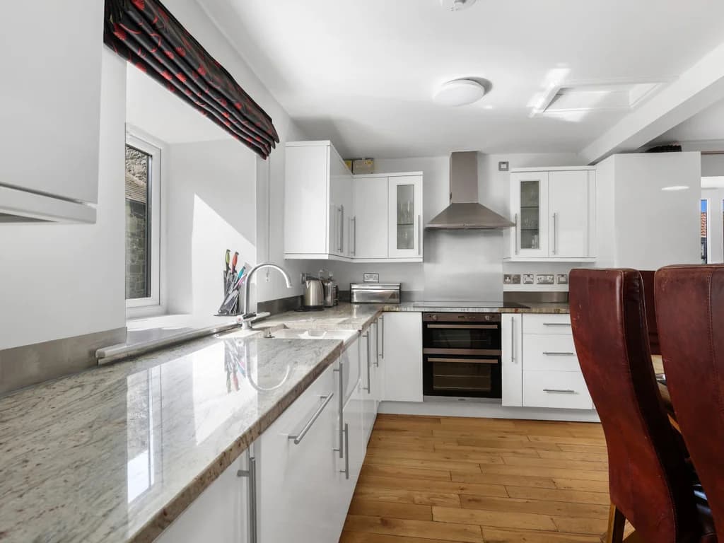 White kitchen with granite worktops and Belfast sink