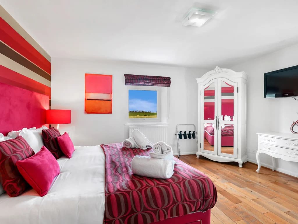 Super-king bedroom with striped feature wall and wardrobe
