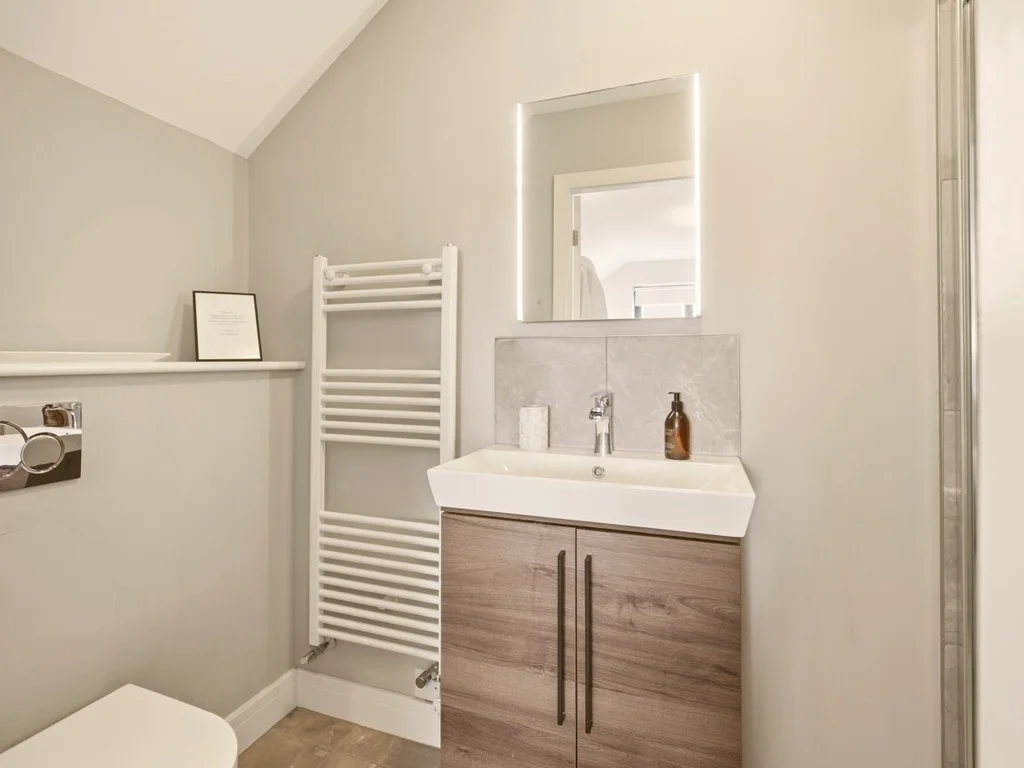 En-suite with vanity basin, heated towel rail and illuminated mirror