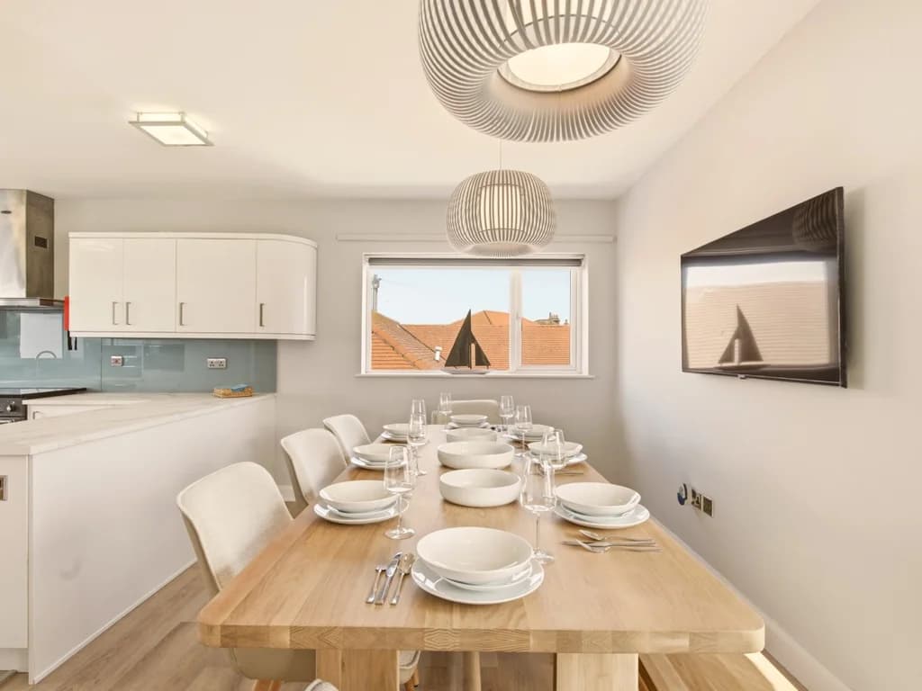 Modern dining space with ample seating beside a fully equipped kitchen
