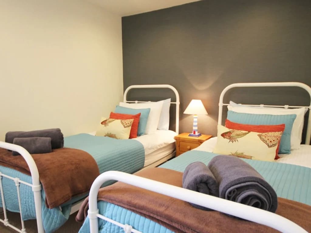 Cosy twin bedroom with two single beds and colourful coastal touches.