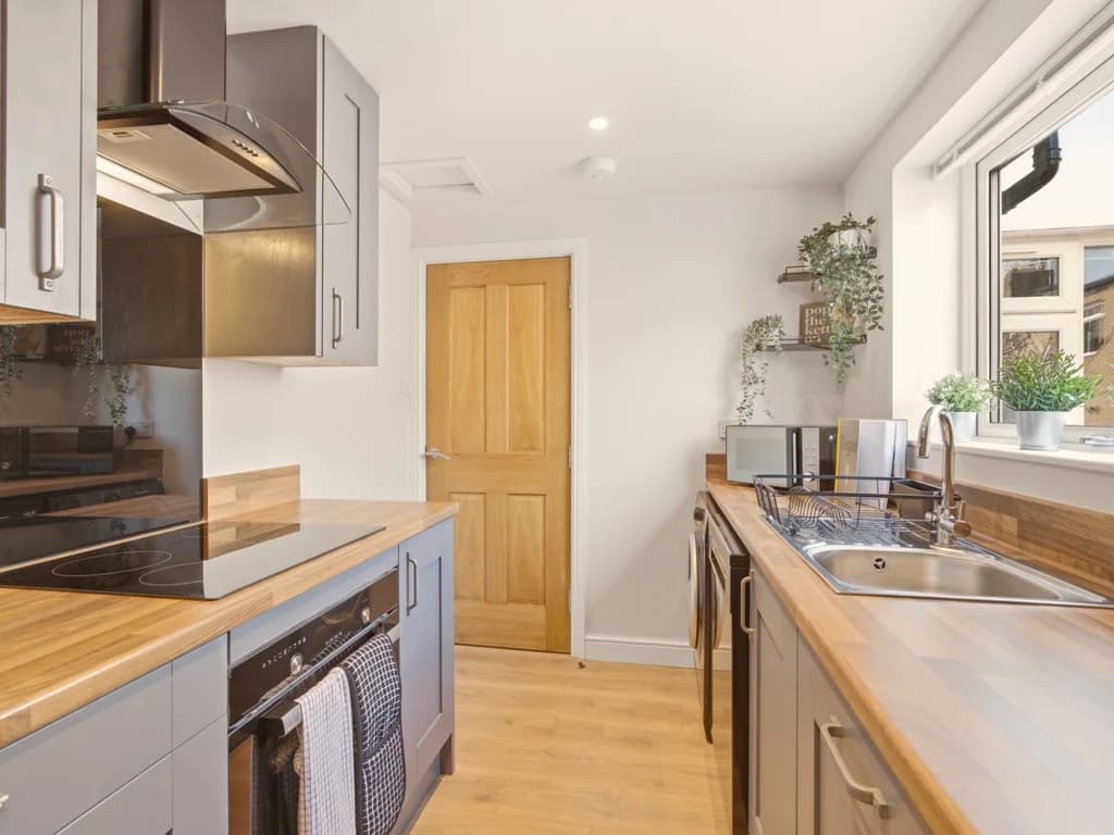 Kitchen with wooden worktops and integrated appliances.