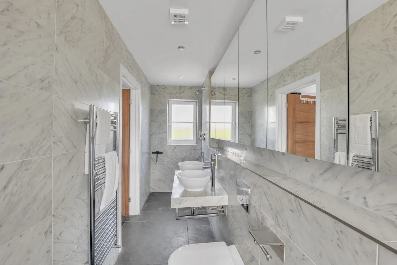 Spacious marble ensuite with walk-in shower and twin basins