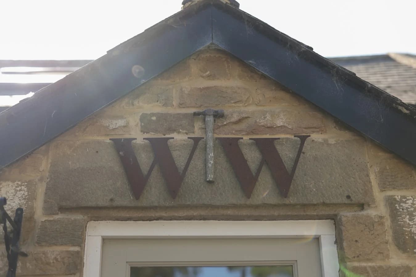 Stone entrance gable with WW initials marking Woodworkers Cottage