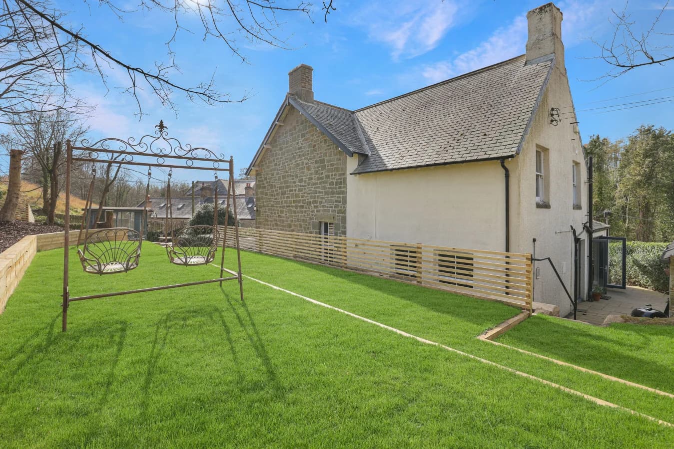Spacious lawned garden with pergola and countryside surroundings