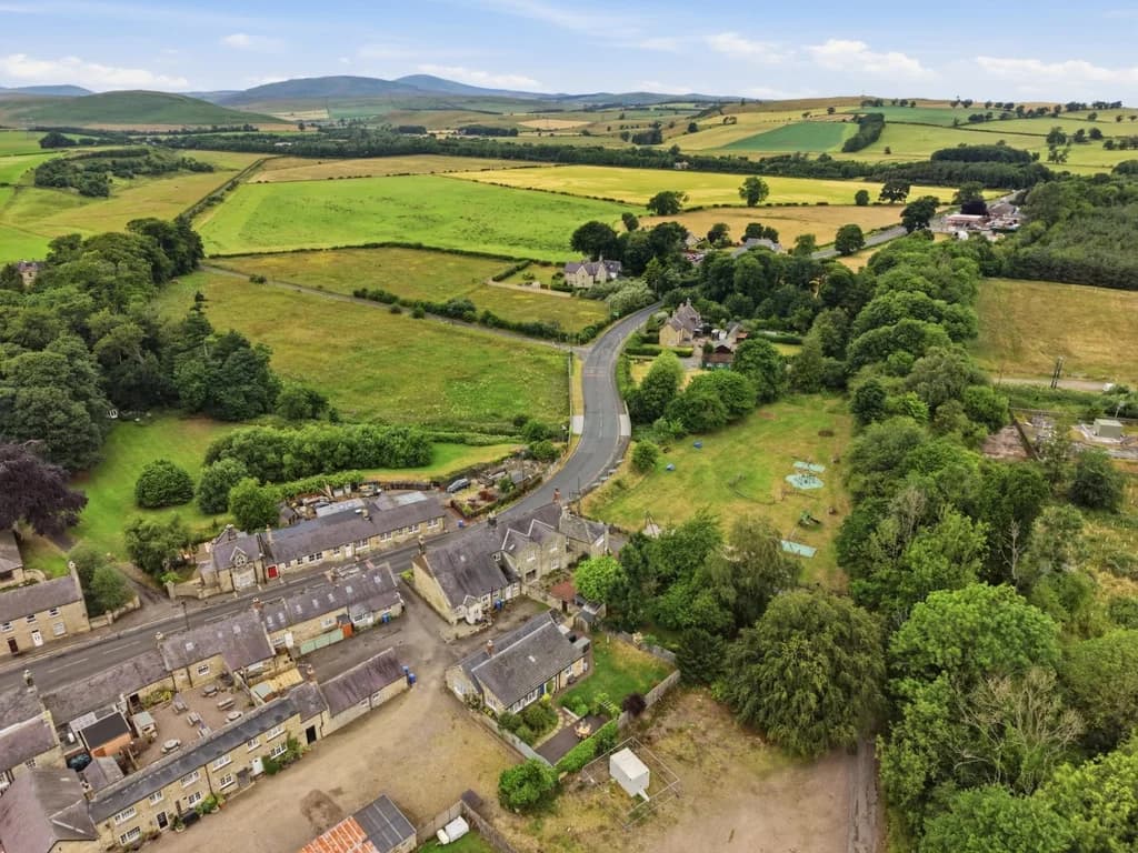 Scenic aerial view of Powburn surrounded by rolling Northumberland countryside