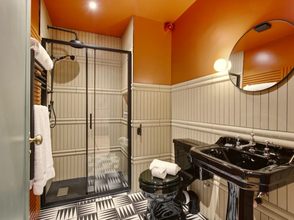 Shower room with black basin, round mirror and walk-in shower