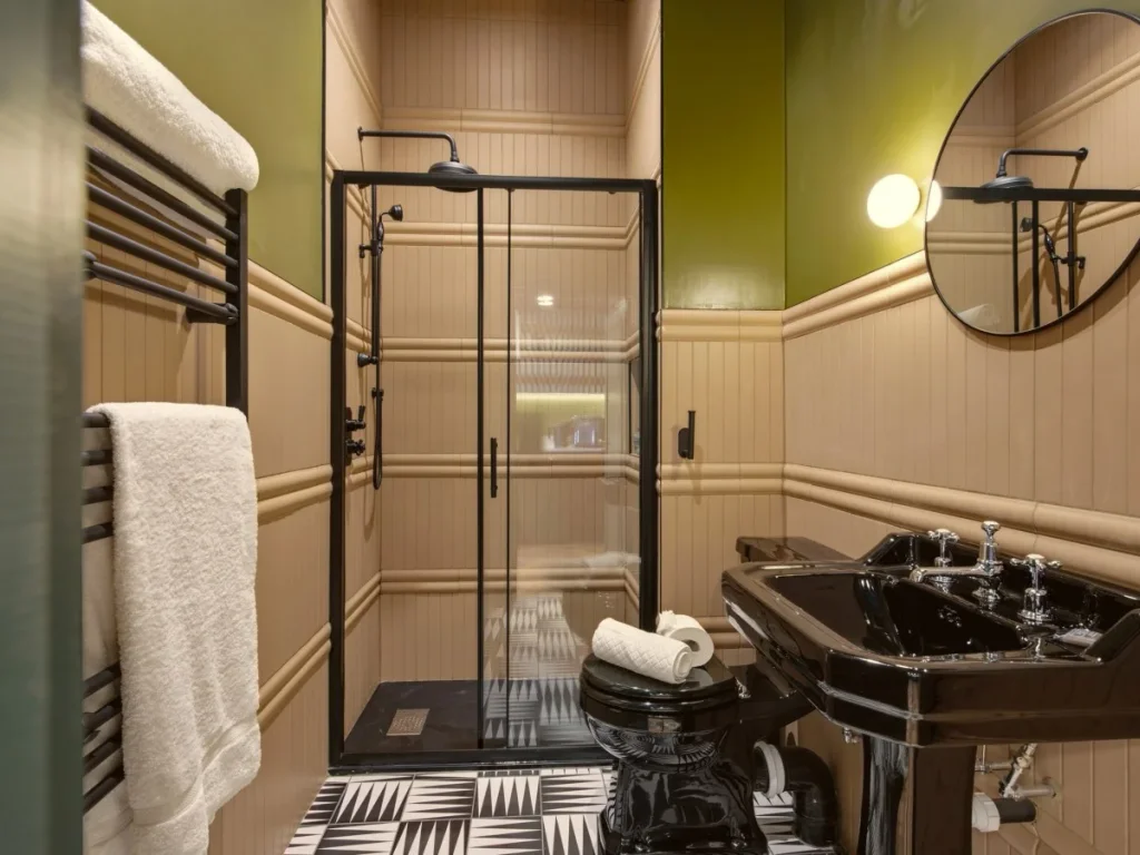 Shower room with walk-in shower, black fittings and round mirror
