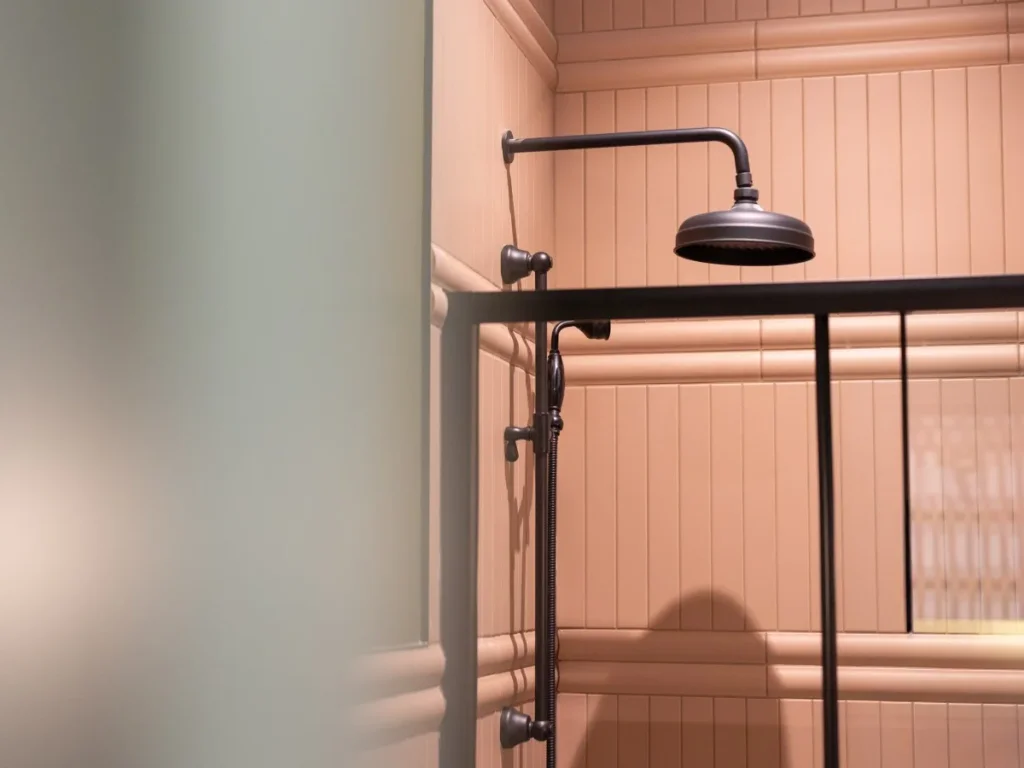 Rainfall shower with black fittings and softly lit panelled walls
