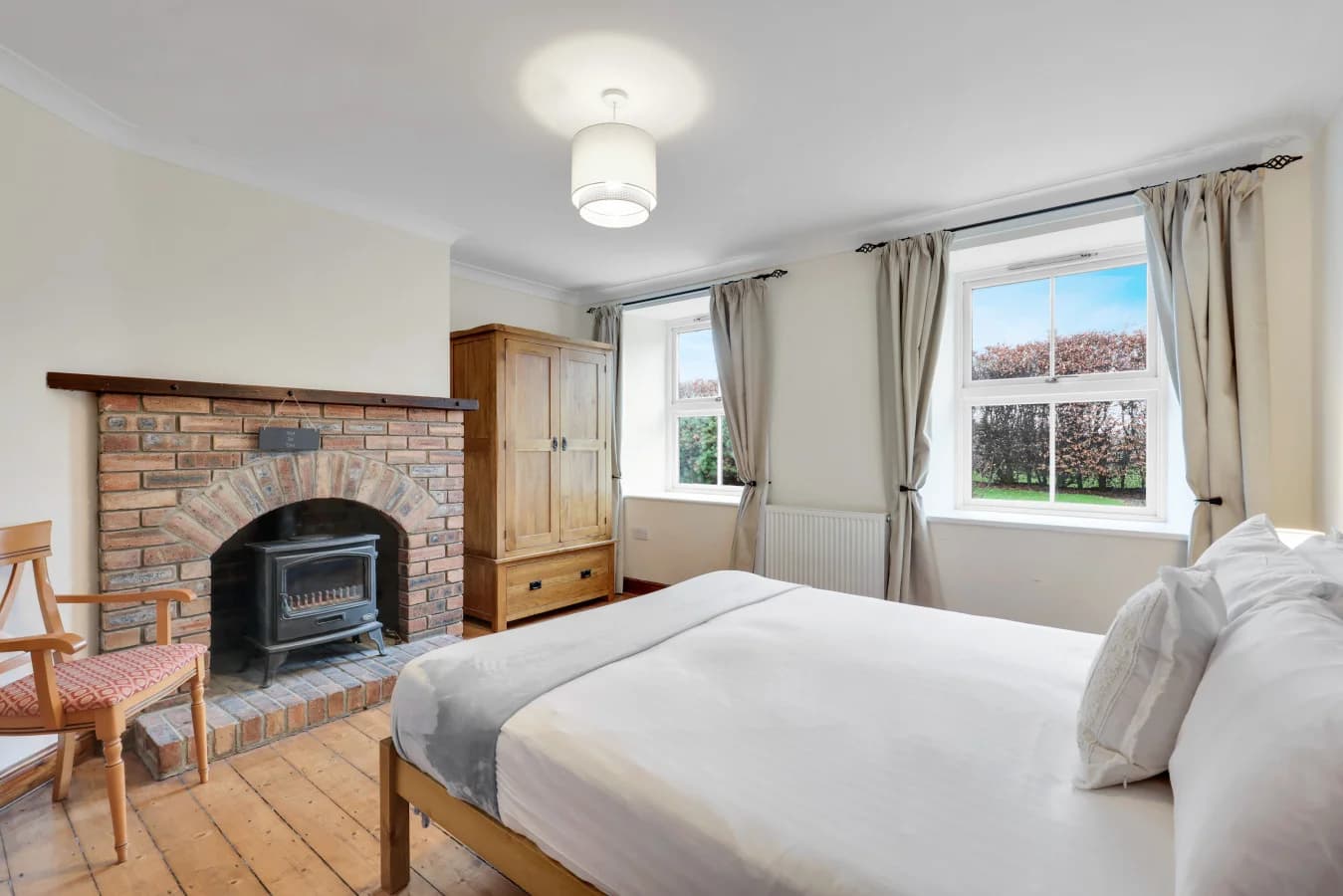 Ground-floor king bedroom with exposed brick fireplace feature