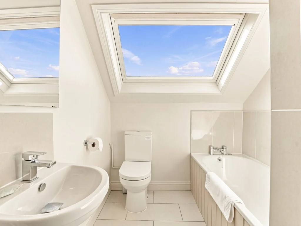 En-suite bathroom with bath, WC, wash basin and skylights
