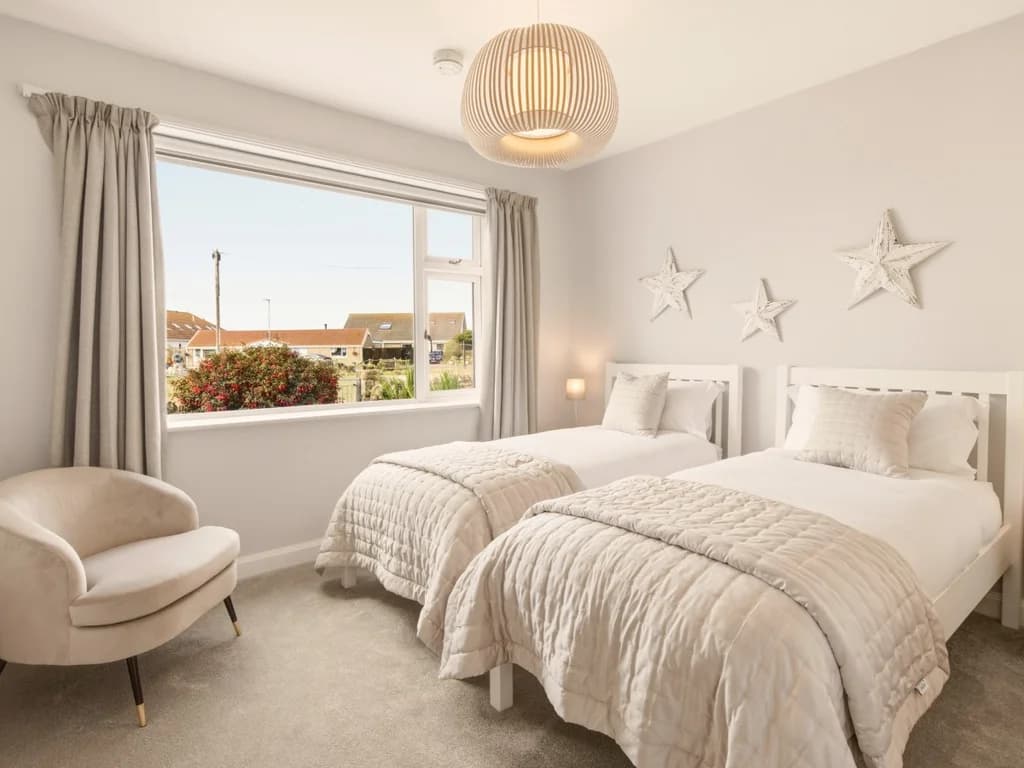 Comfortable twin bedroom with coastal-inspired décor and village views