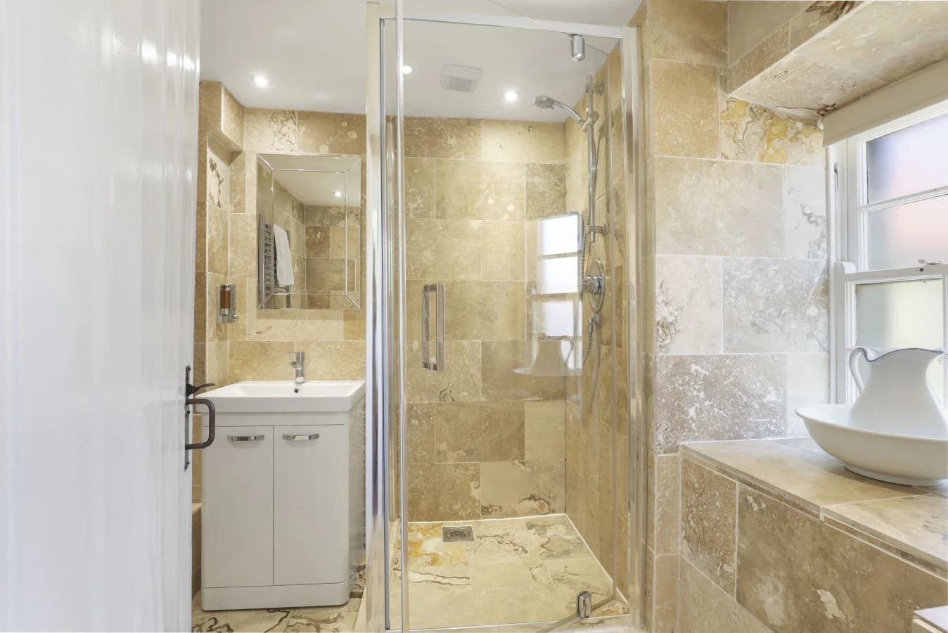 Travertine bathroom with walk-in shower and vanity unit