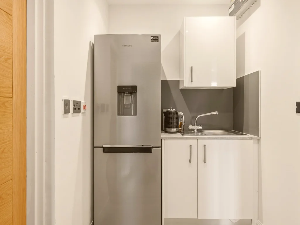 Handy utility room with fridge freezer, sink and additional storage space