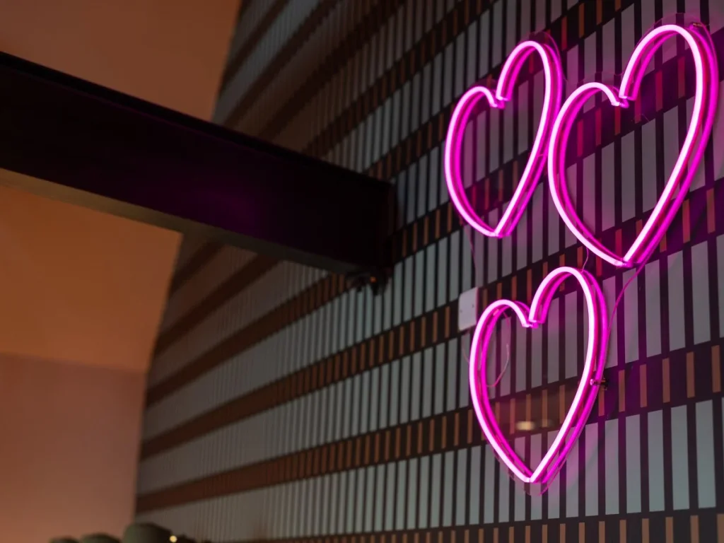 Pink heart neon lights adding character to the patterned feature wall