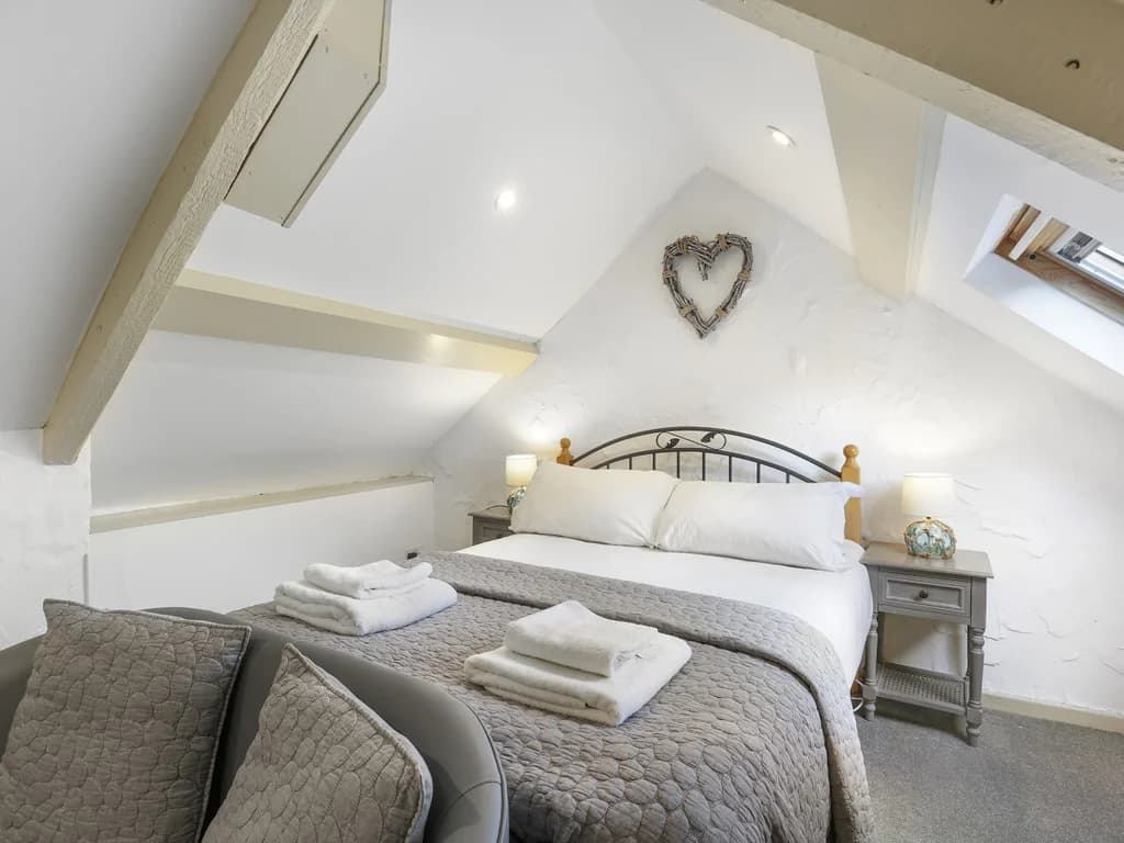 Double bedroom beneath vaulted ceilings with exposed beams