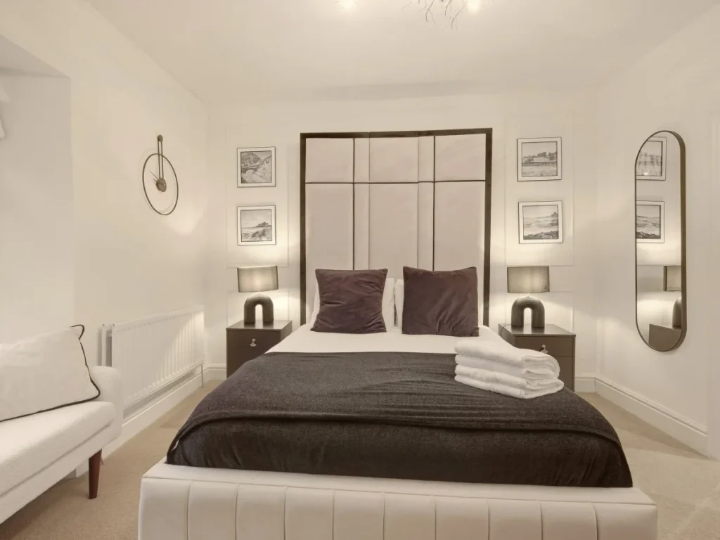 First-floor double bedroom with upholstered bed, bedside lamps and mirrors.