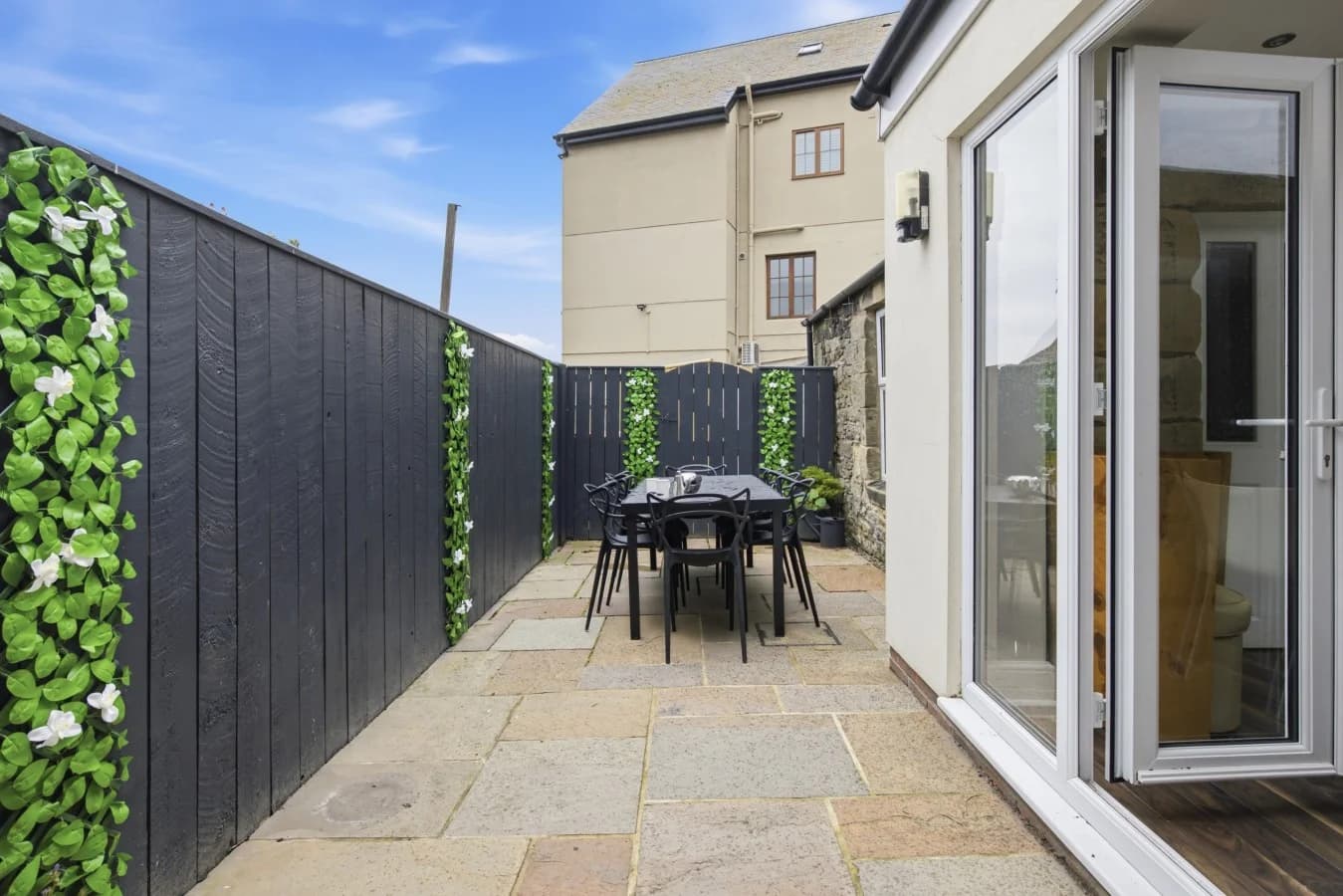 Rear courtyard with barbecue, dining table and seating