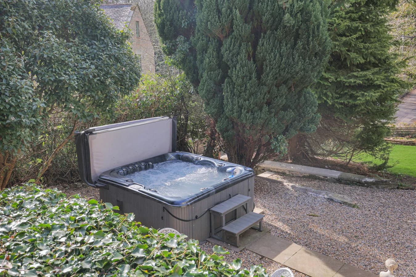 Private hot tub set among mature greenery in the garden
