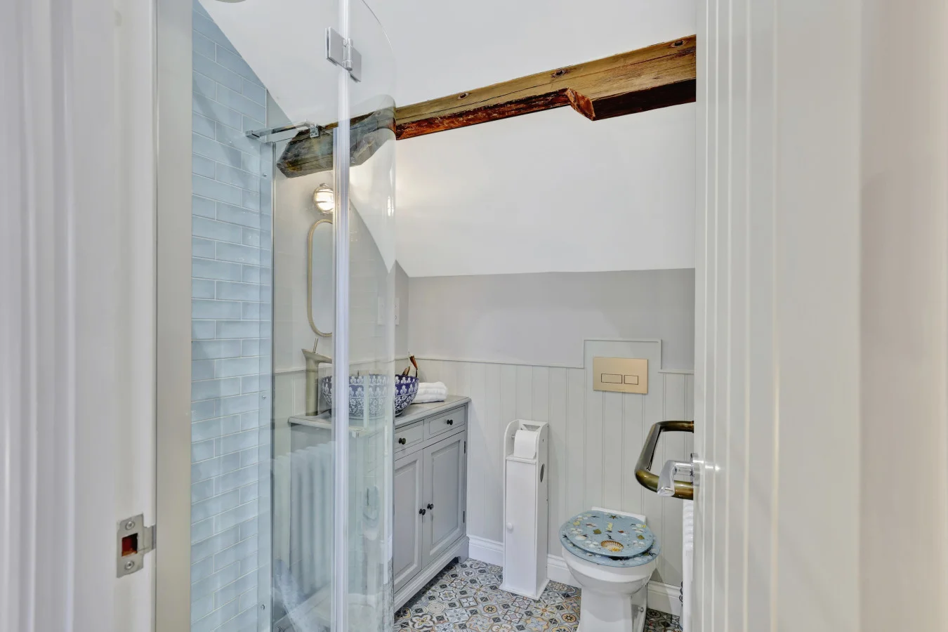 En-suite bathroom with walk-in shower and decorative tiled flooring