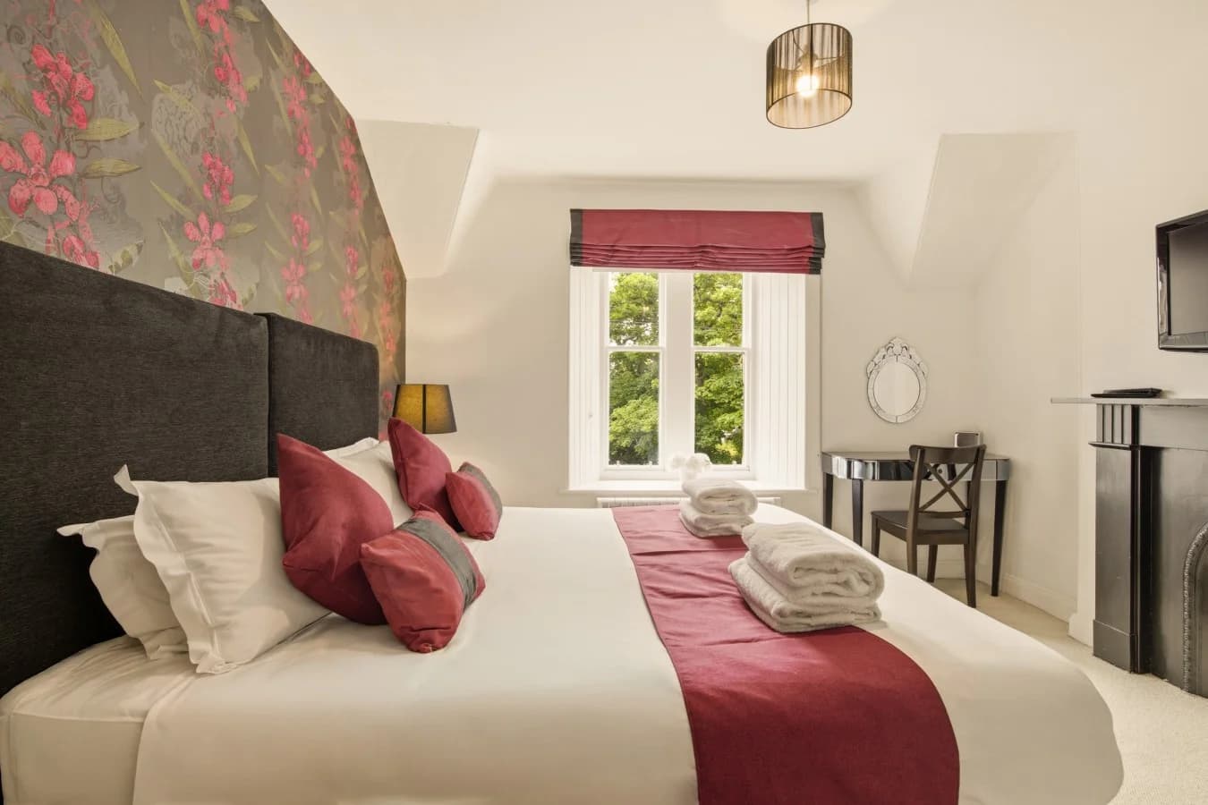 Super king bedroom with floral feature wall and window seat