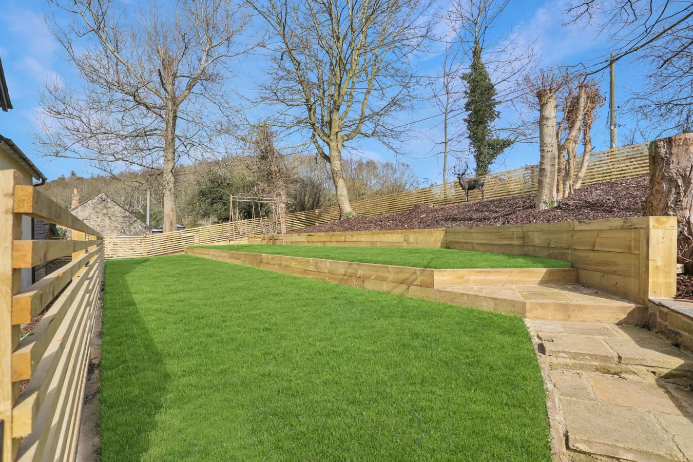 Landscaped garden with lawn, stone pathway and raised timber beds
