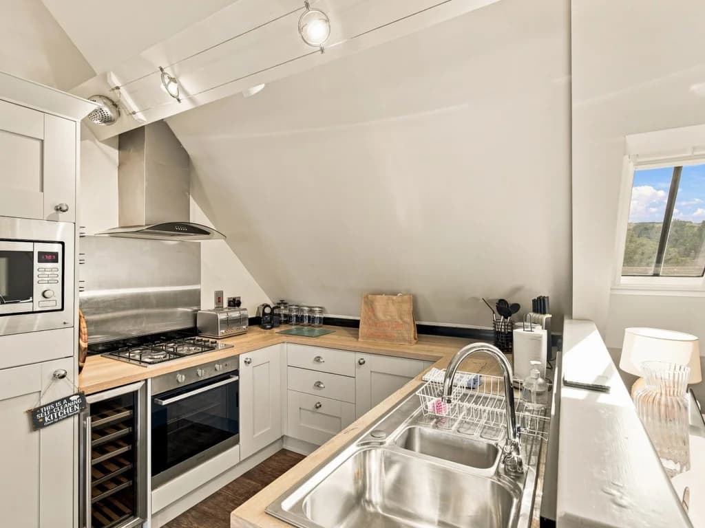 Open-plan dining area beneath vaulted ceilings and feature windows.