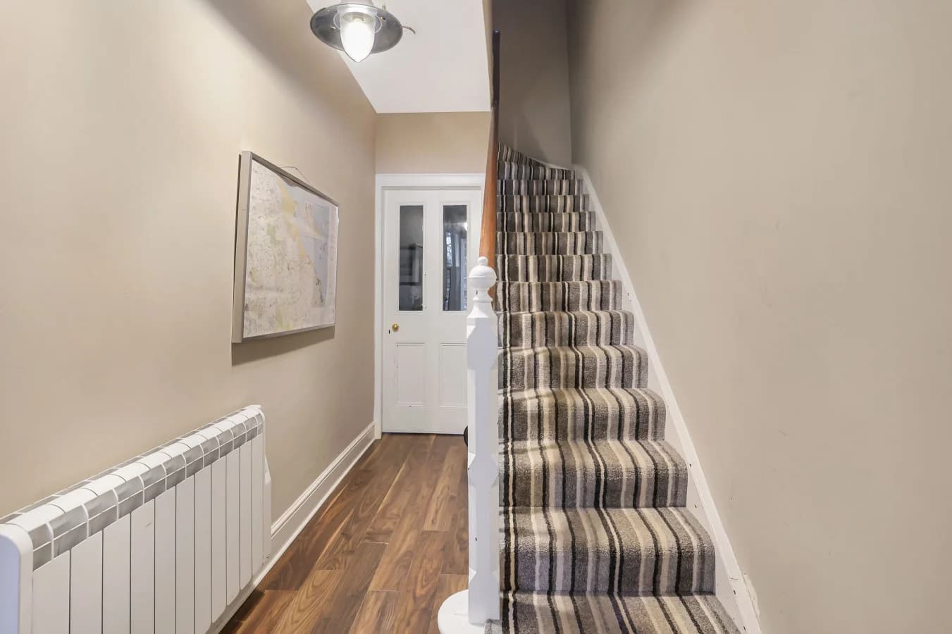 Hallway with oak flooring and carpeted staircase