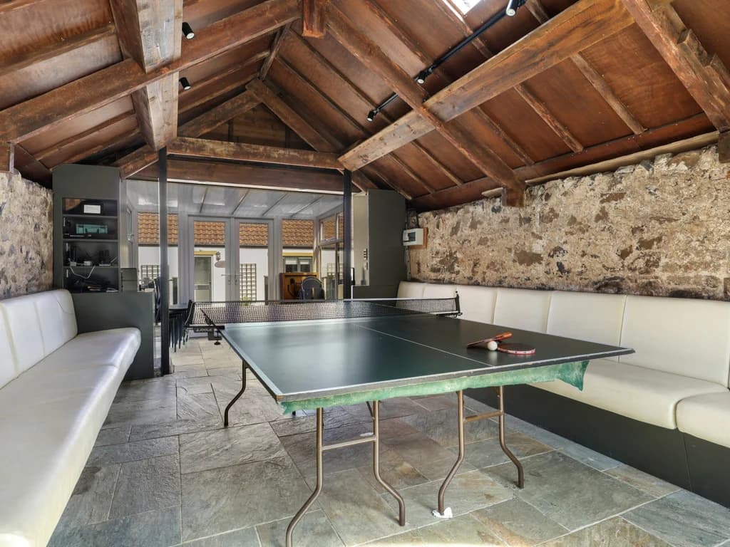 Table tennis area with exposed stone walls and slate flooring.