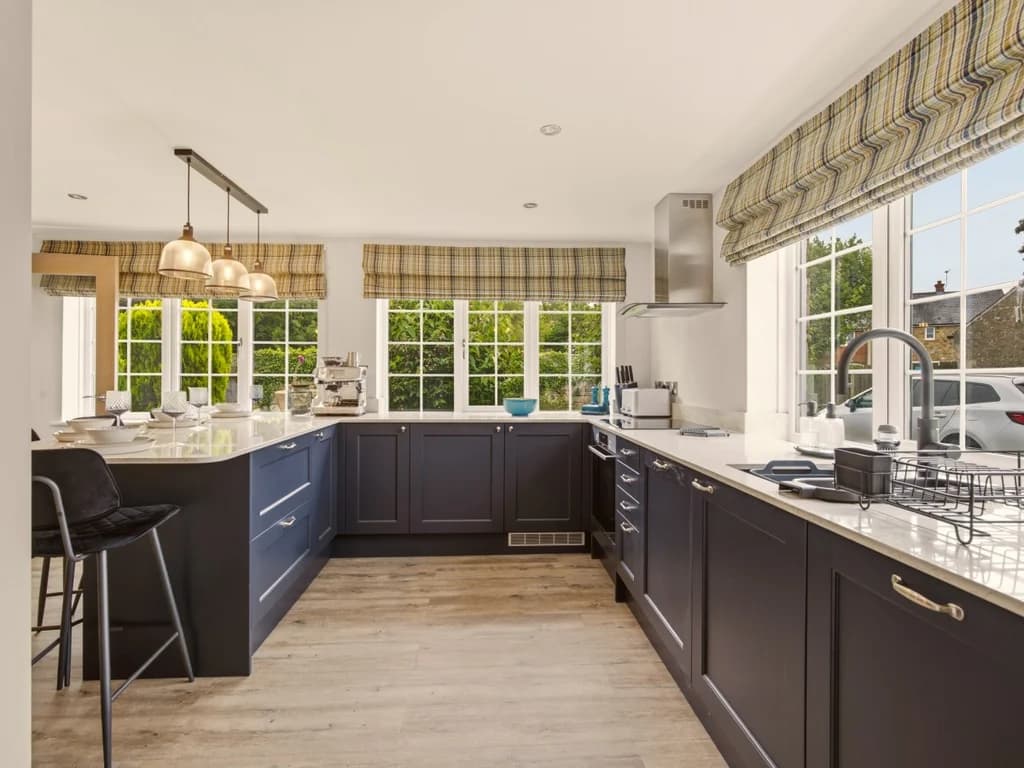 Contemporary kitchen with navy cabinetry, quartz worktops and breakfast bar