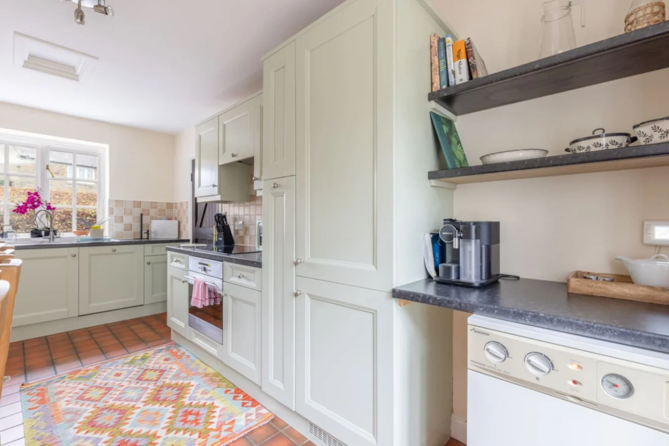 Well-equipped kitchen with stone-effect worktops and open shelving