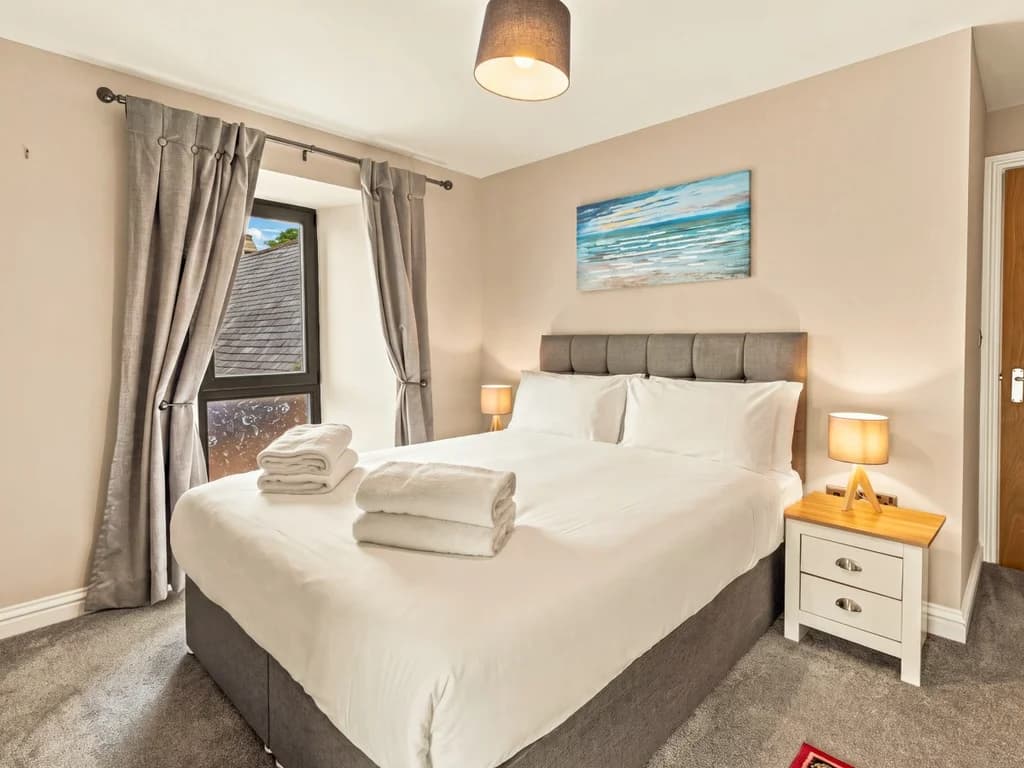Double bedroom with upholstered headboard and bedside lighting.