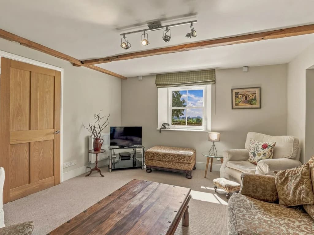 Comfortable living area with TV, armchairs and countryside view