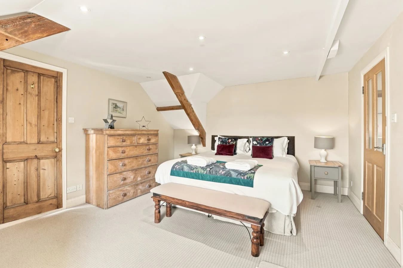 King bedroom with wooden furniture and exposed timber details