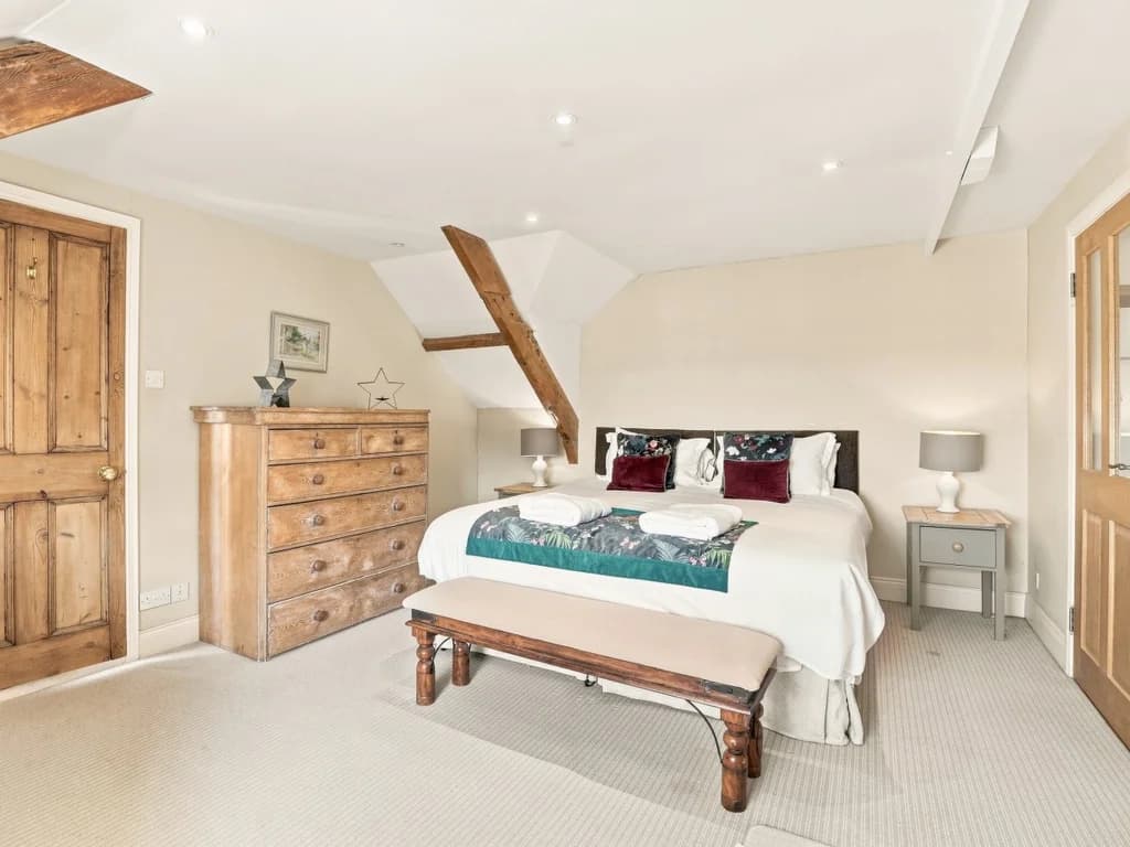 King bedroom with wooden furniture and exposed timber details