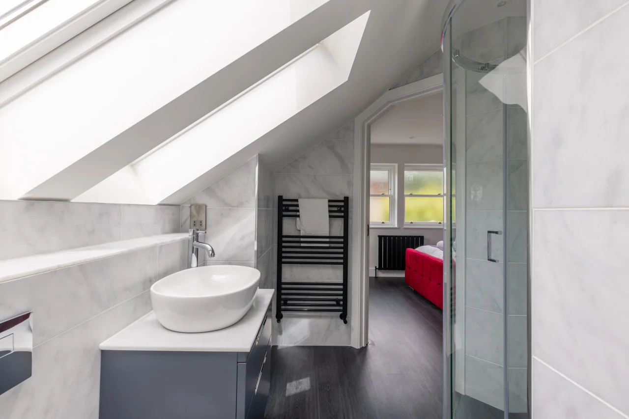 En-suite shower room with vessel basin, heated towel rail and skylight