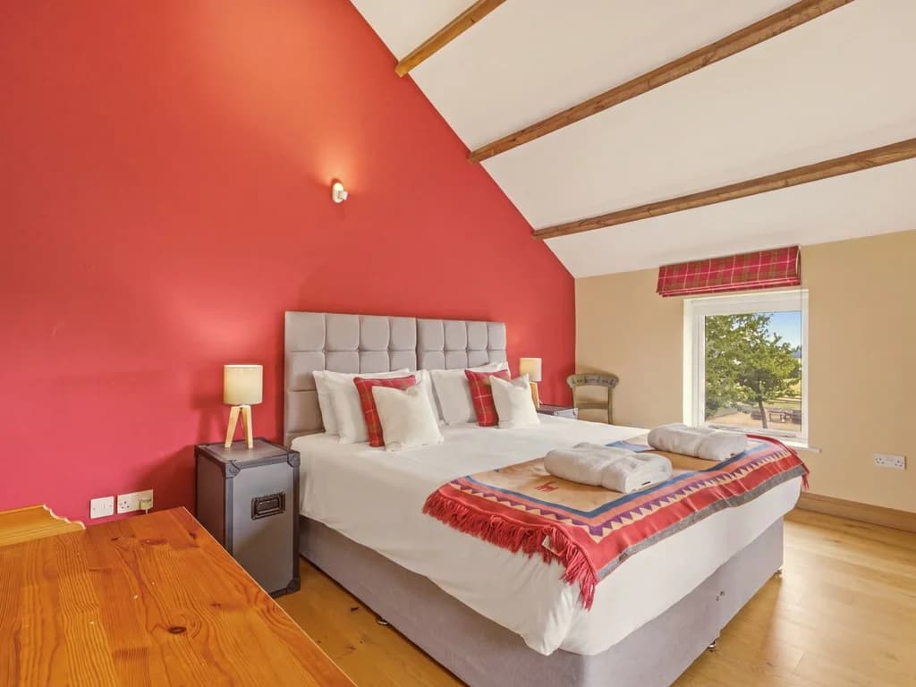 Spacious king-size bedroom with bright windows and timber flooring
