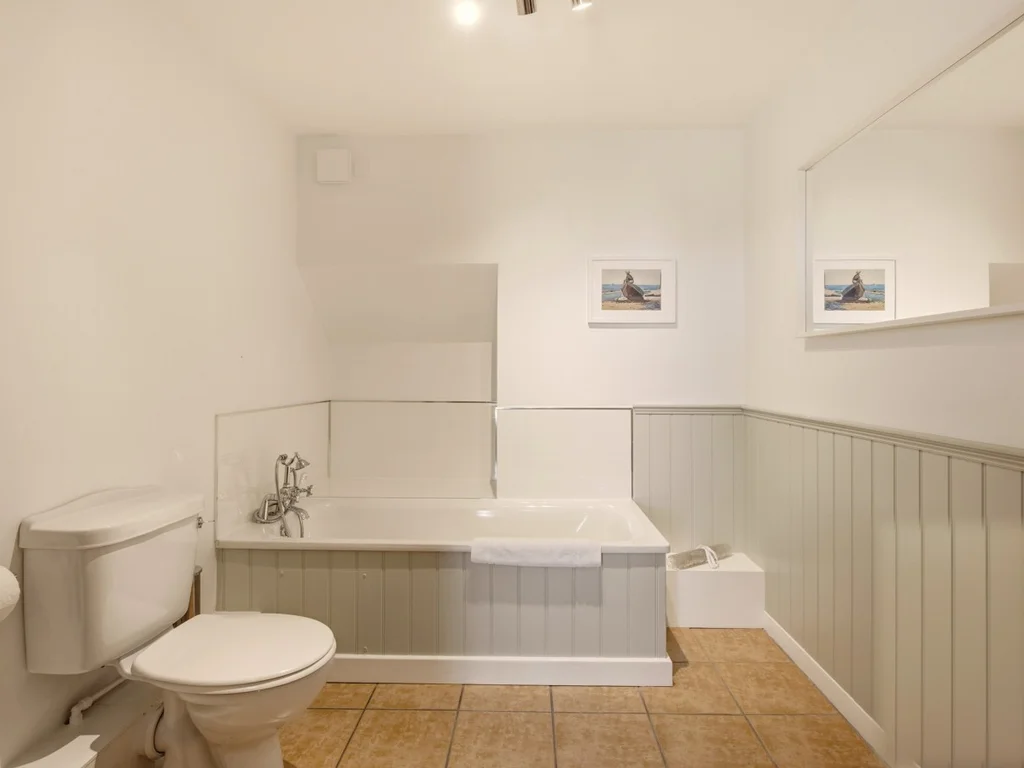Family bathroom with bath, shower attachment and painted tongue-and-groove walls