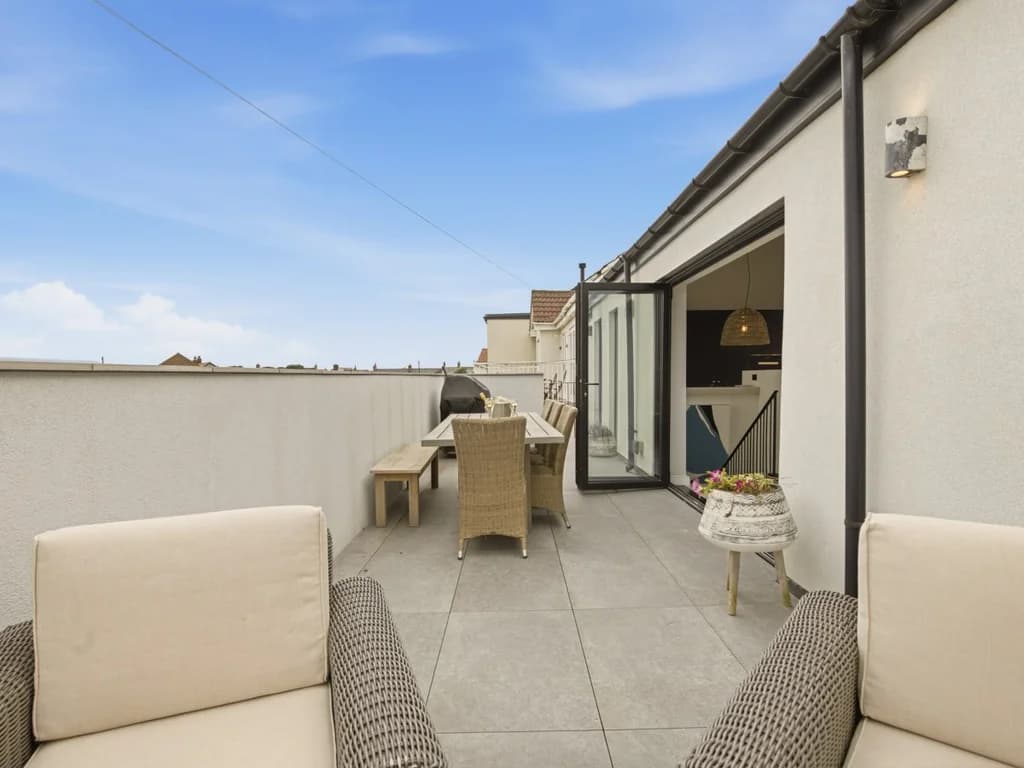 Spacious balcony with outdoor dining set and bifold doors to living area