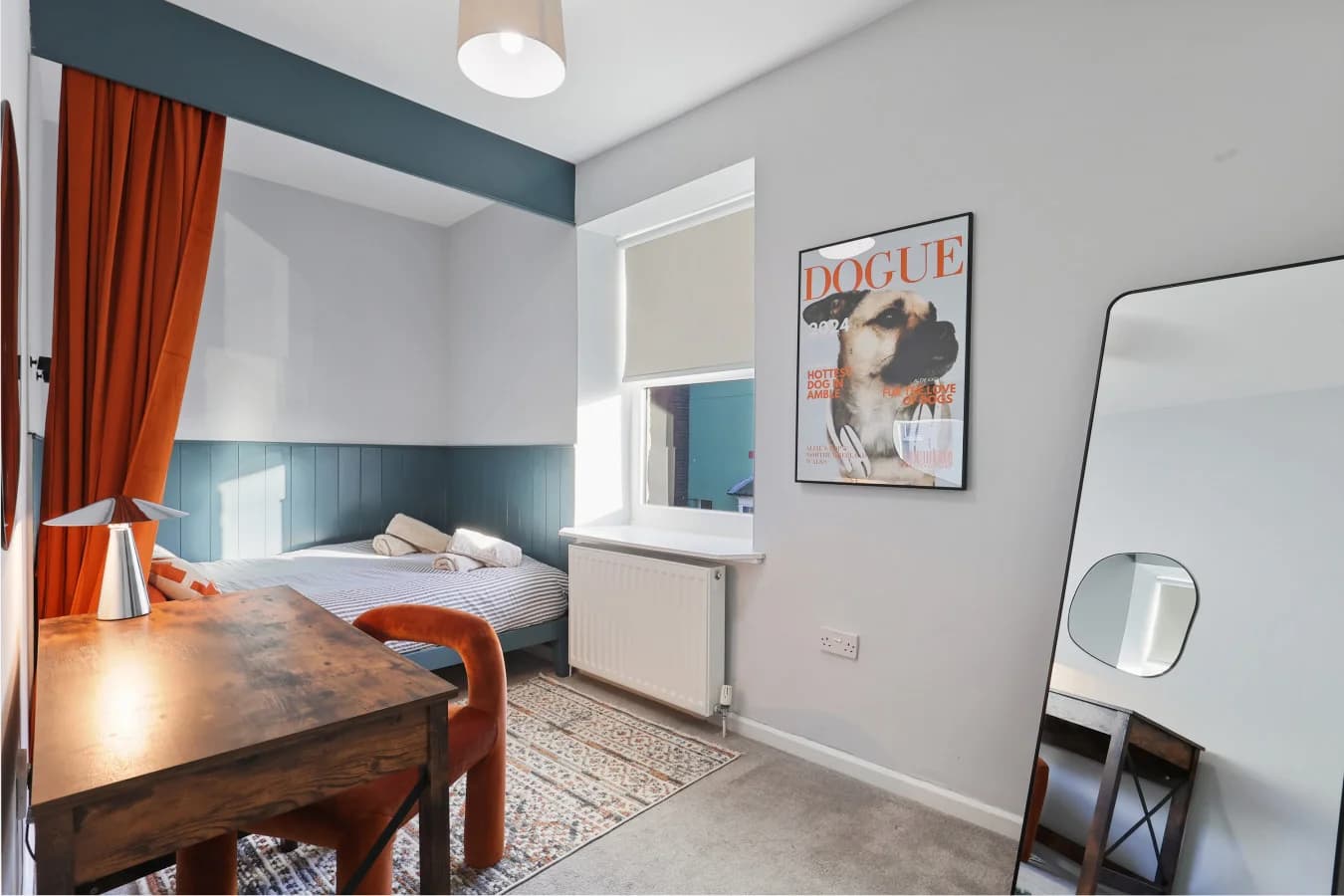 Cosy double bedroom with burnt orange accents and a dedicated workspace