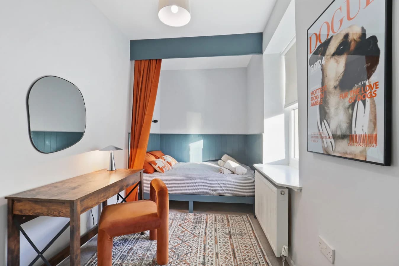Stylish guest bedroom featuring a panelled bed nook and statement artwork