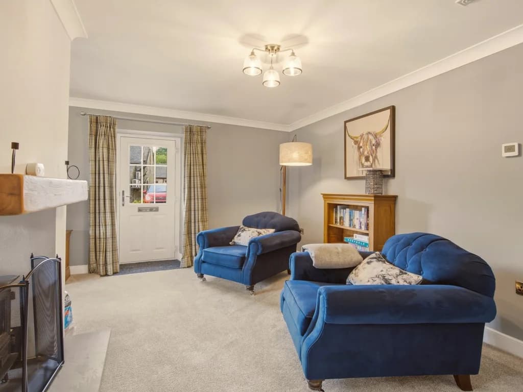 Inviting living room with plush seating leading to the doors to the front entrance