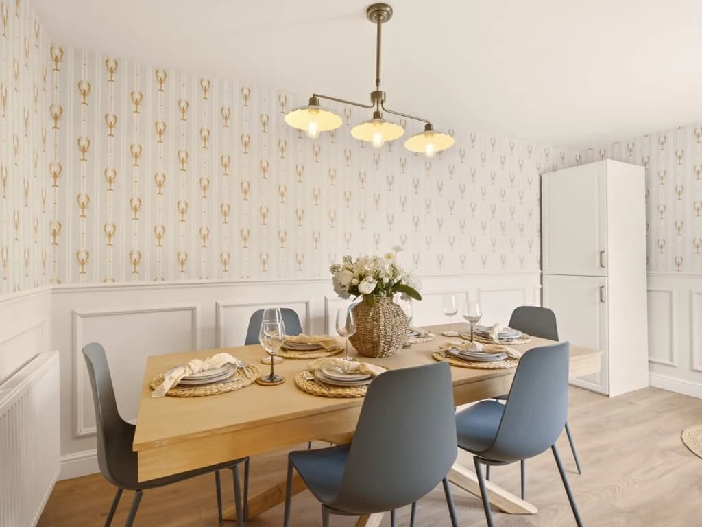 Dining room with wooden table, patterned wallpaper and seating for six