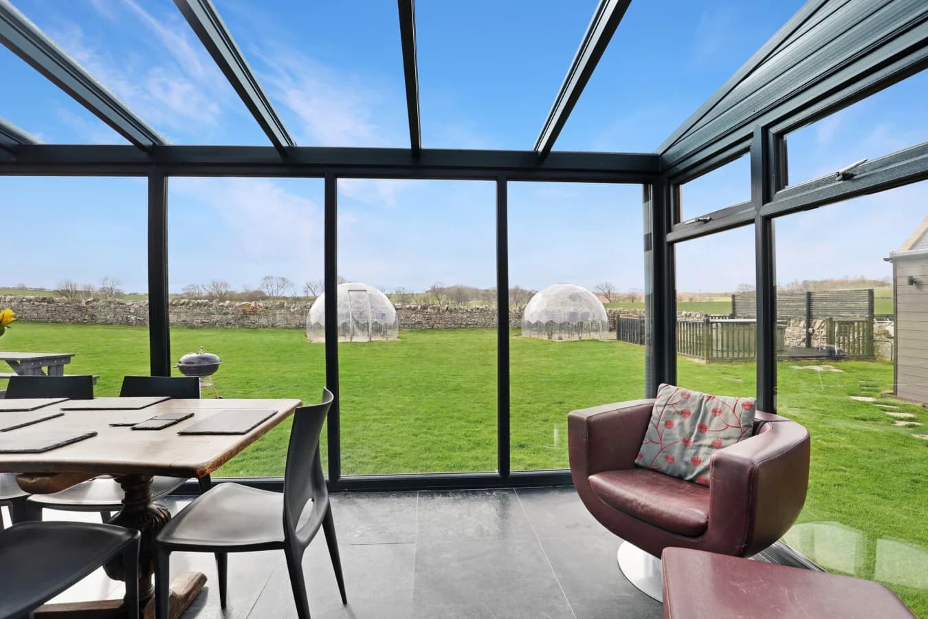 Conservatory seating and dining area overlooking the lawn
