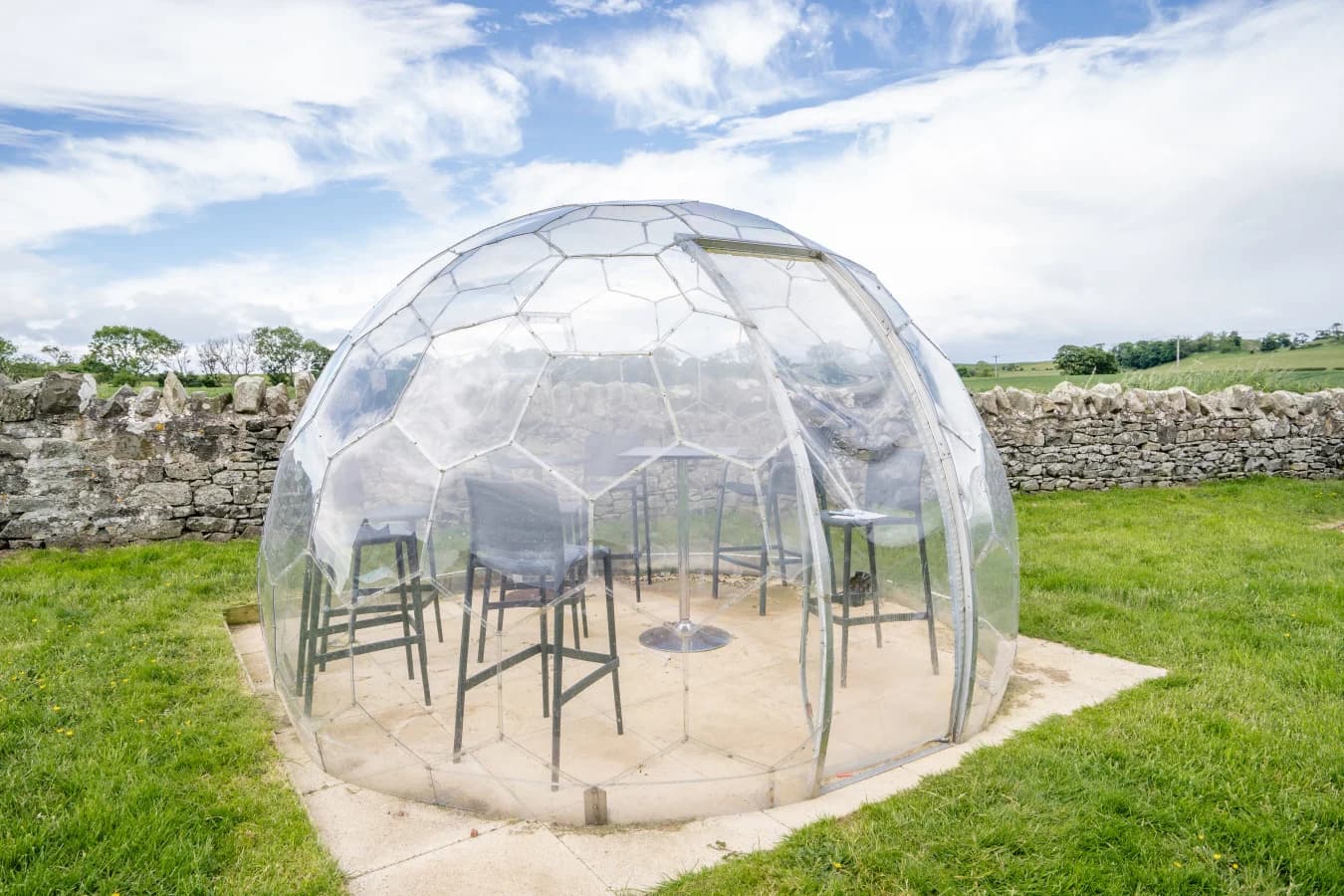 Clear dome dining pod set within the shared garden