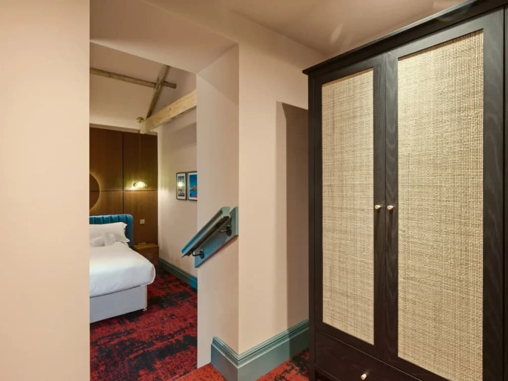 Bedroom entrance with woven wardrobe and wood-panelled feature wall