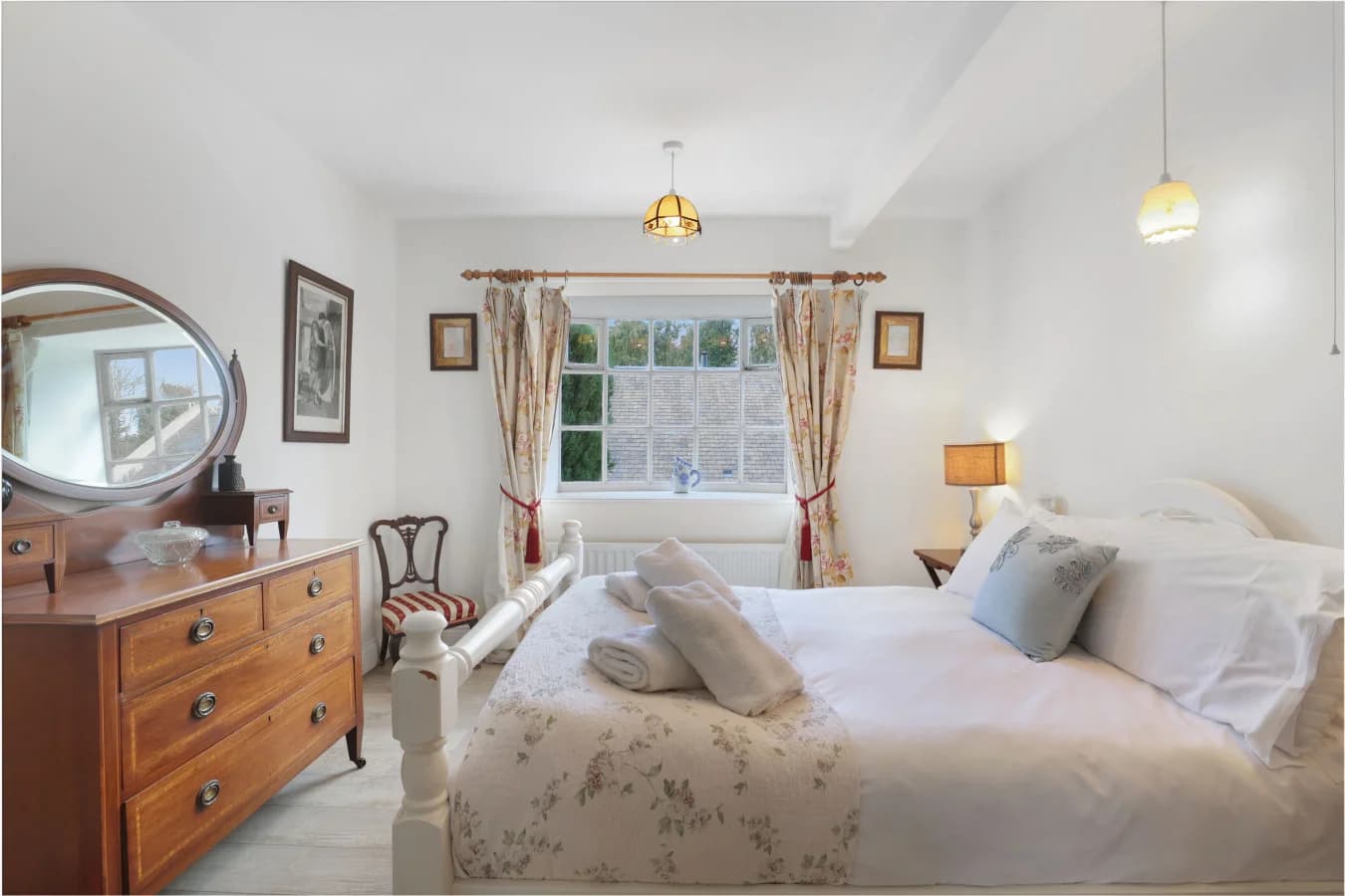 Garden-facing bedroom with floral textiles and period furniture